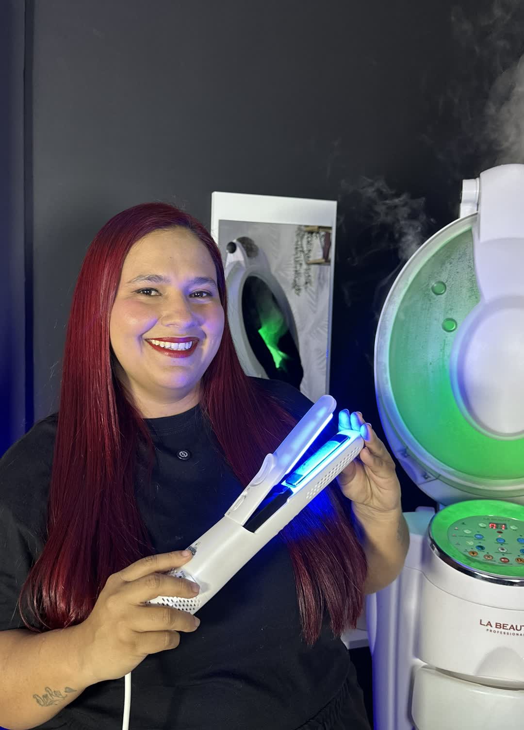Way Prieto en su estudio capilar sosteniendo una plancha profesional junto a un vaporizador.